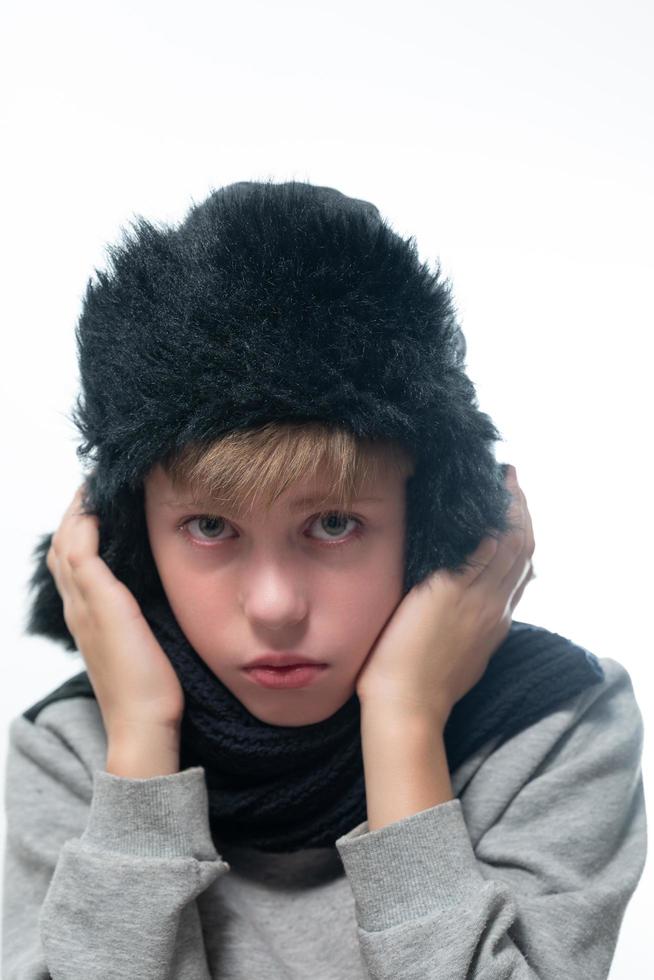 Portrait of upset guy in winter hat and scarf, cold winter and crisis time. photo