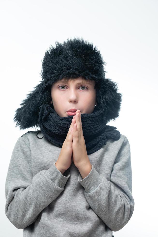 Winter hat with earflaps and scarf, portrait of a boy in winter clothes. photo