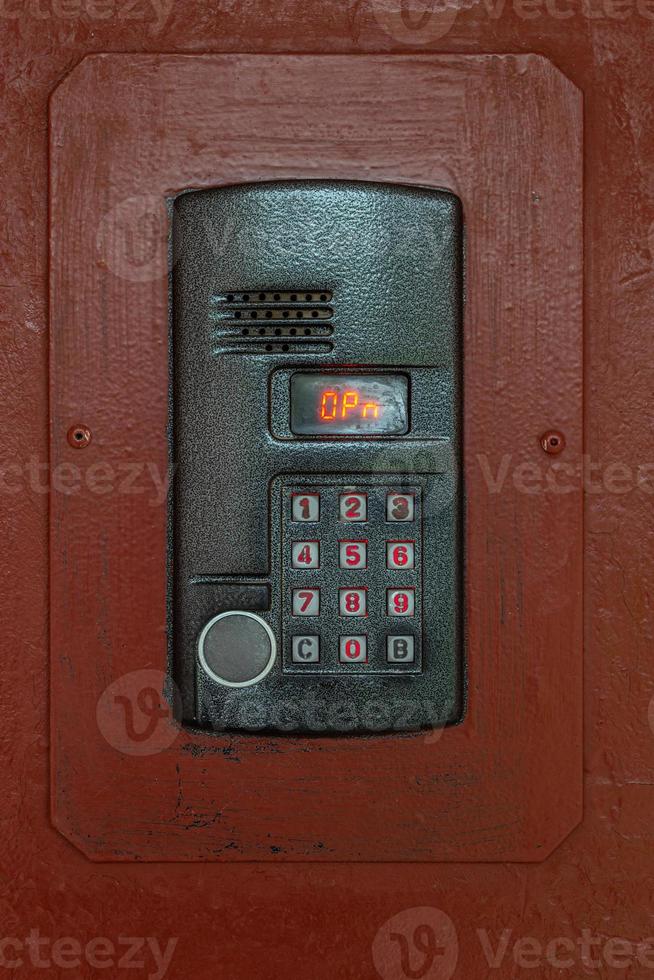 an intercom on old painted brown steel surface with a keypad, digital display and rfid sensor for calling close-up photo