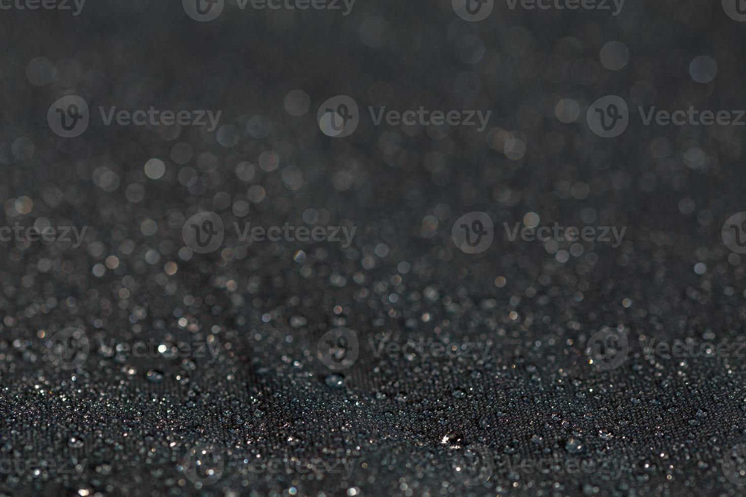 dark gray waterproof hydrophobic flat cloth closeup with rain drops photo