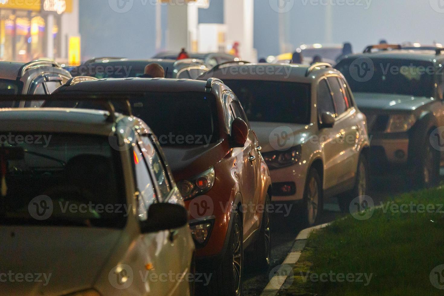 cars stuck in traffic jam at gas station at foggy night during supply crunch photo