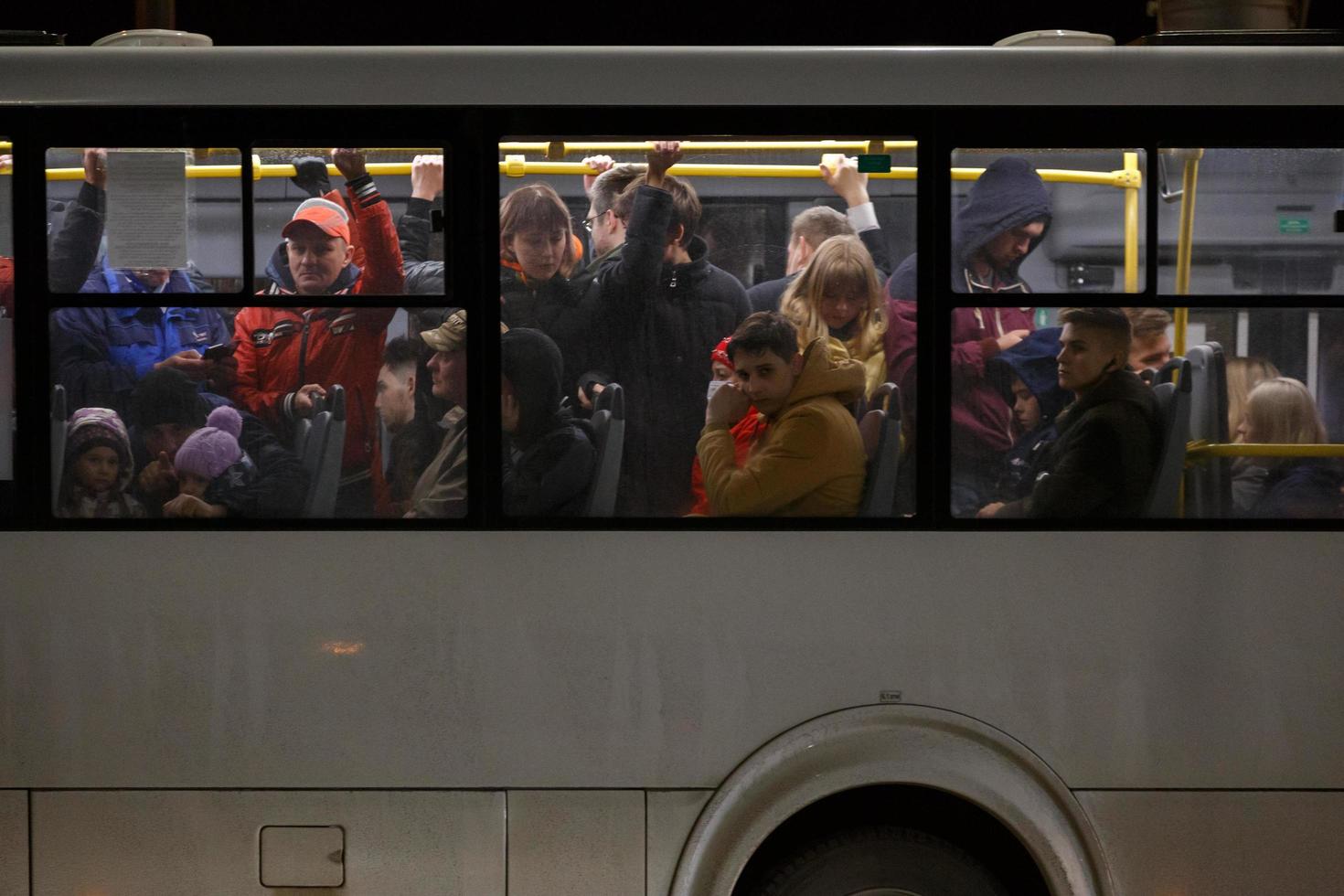 tula, rusia 9 de mayo de 2021 multitud de personas en autobús público blanco en la noche de primavera, vista lateral desde el exterior foto