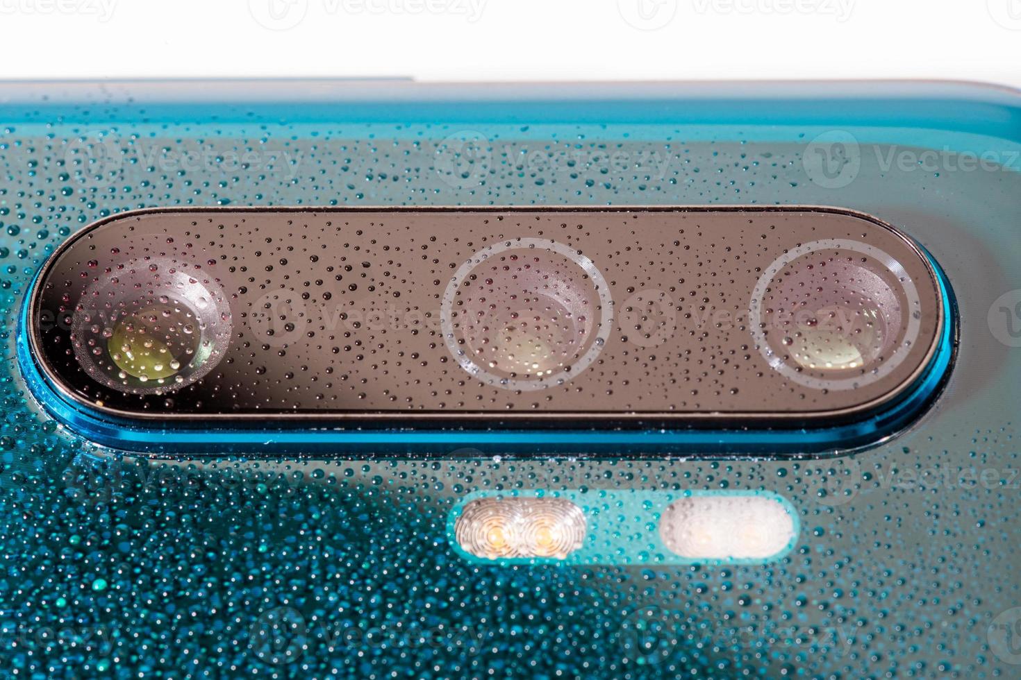 aurora green pearl phone camera lens covered with small water drops - close-up with selective focus and blur photo