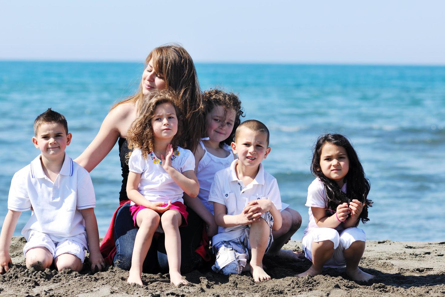 group portrait of childrens with teacher on beach photo