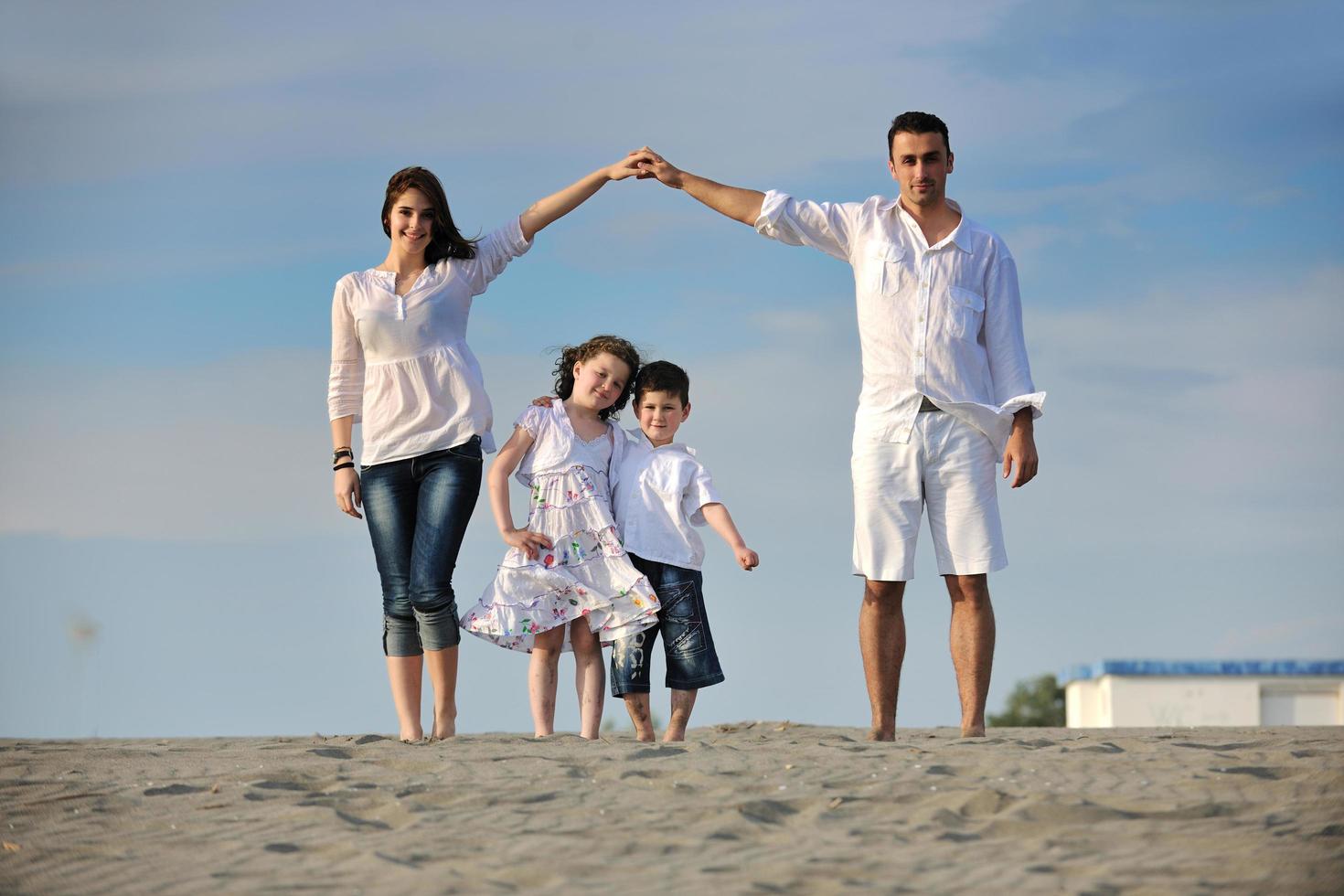 family on beach showing home sign photo