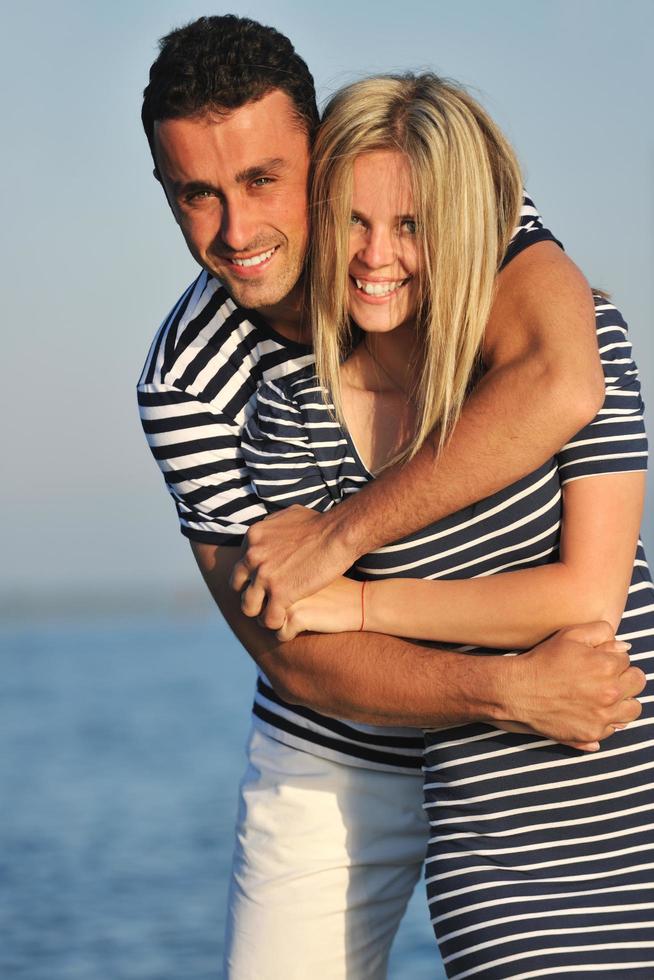 feliz pareja joven tiene tiempo romántico en la playa foto