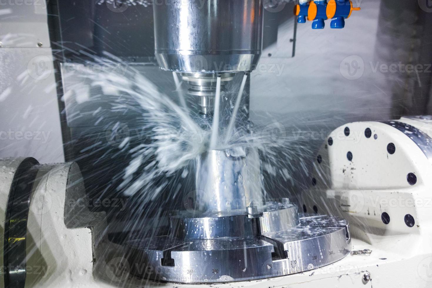 5-axis cnc milling machine at work with coolant under pressure and motion blur of streams.. photo