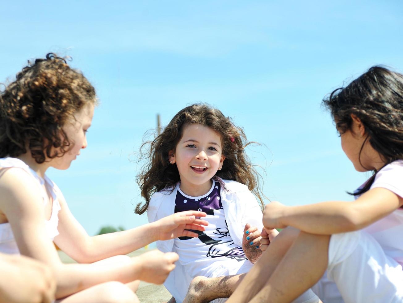 Grupo de niños felices jugando en la playa foto