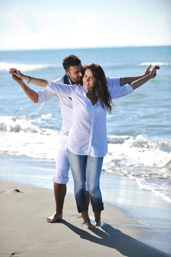 feliz pareja joven divertirse en la hermosa playa foto