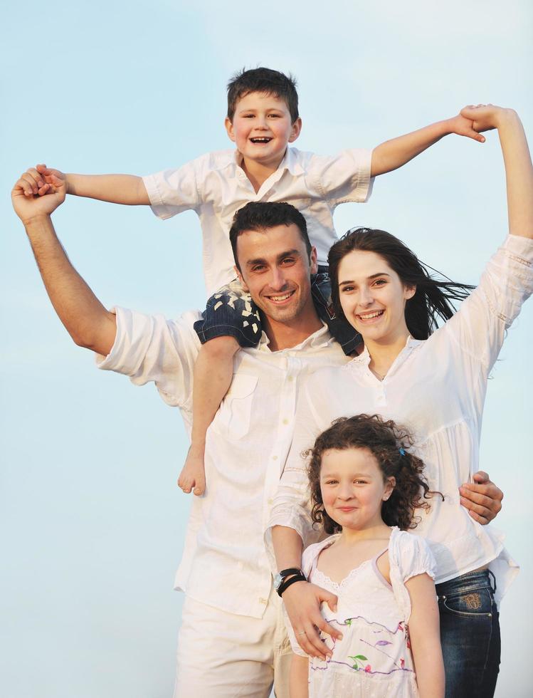 familia joven feliz divertirse en la playa foto