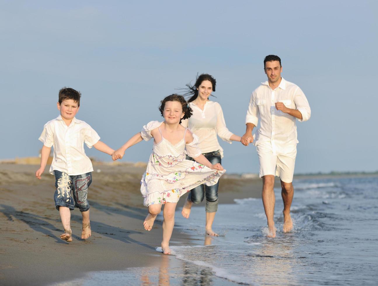 happy young family have fun on beach at sunset photo