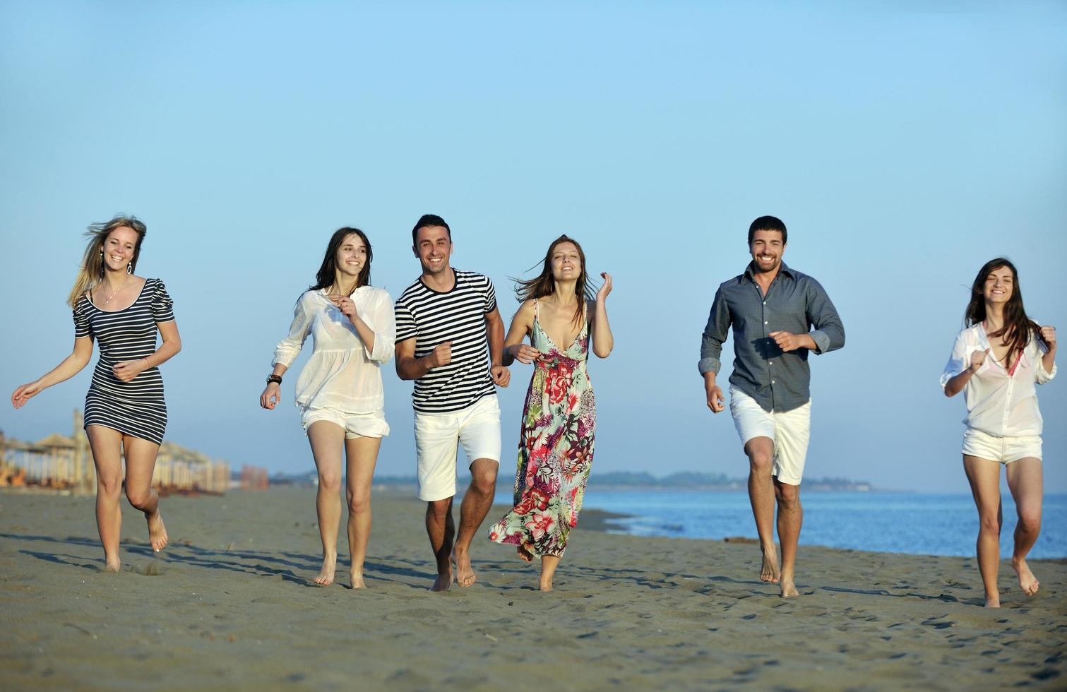 grupo de jóvenes felices divertirse en la playa foto