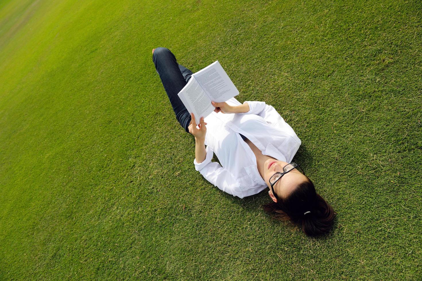 Young woman reading a book in the park photo