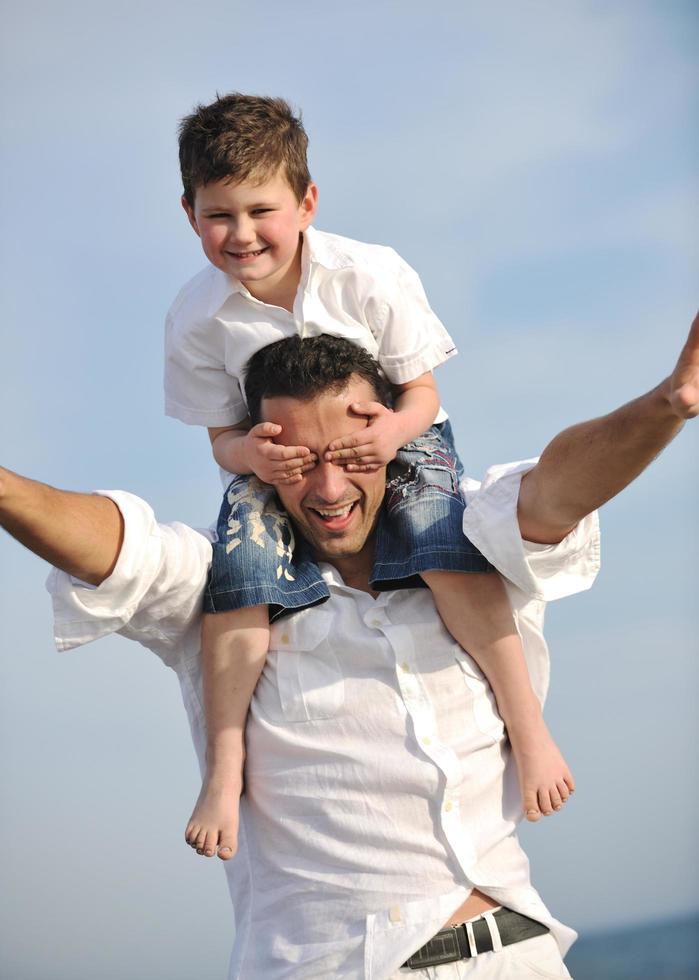 happy father and son have fun and enjoy time on beach photo