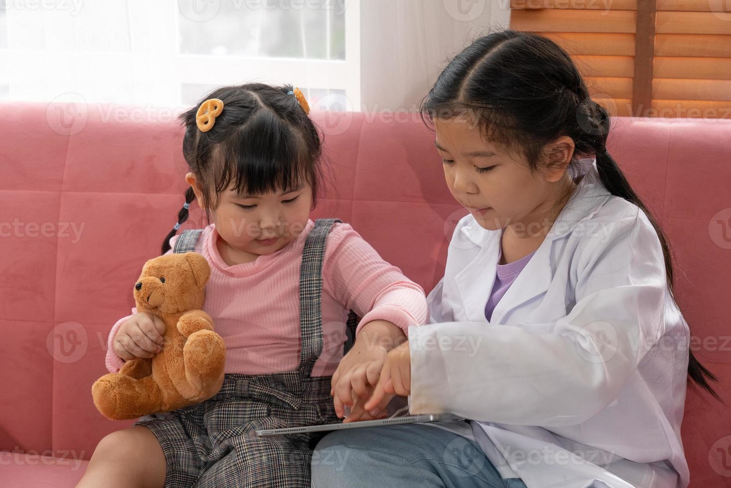 Two Children Playing Toys and Watching Digital Tablet Together in Oiving Room photo