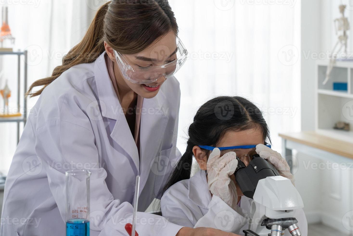Child Learn Chemistry and Science in Laboratory with Teacher photo