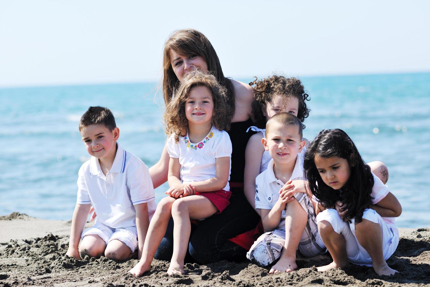 retrato de grupo de niños con profesor en la playa foto