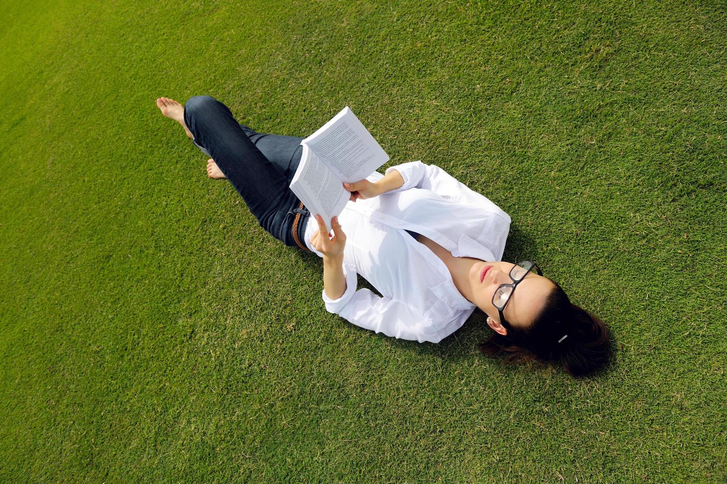 Young woman reading a book in the park photo