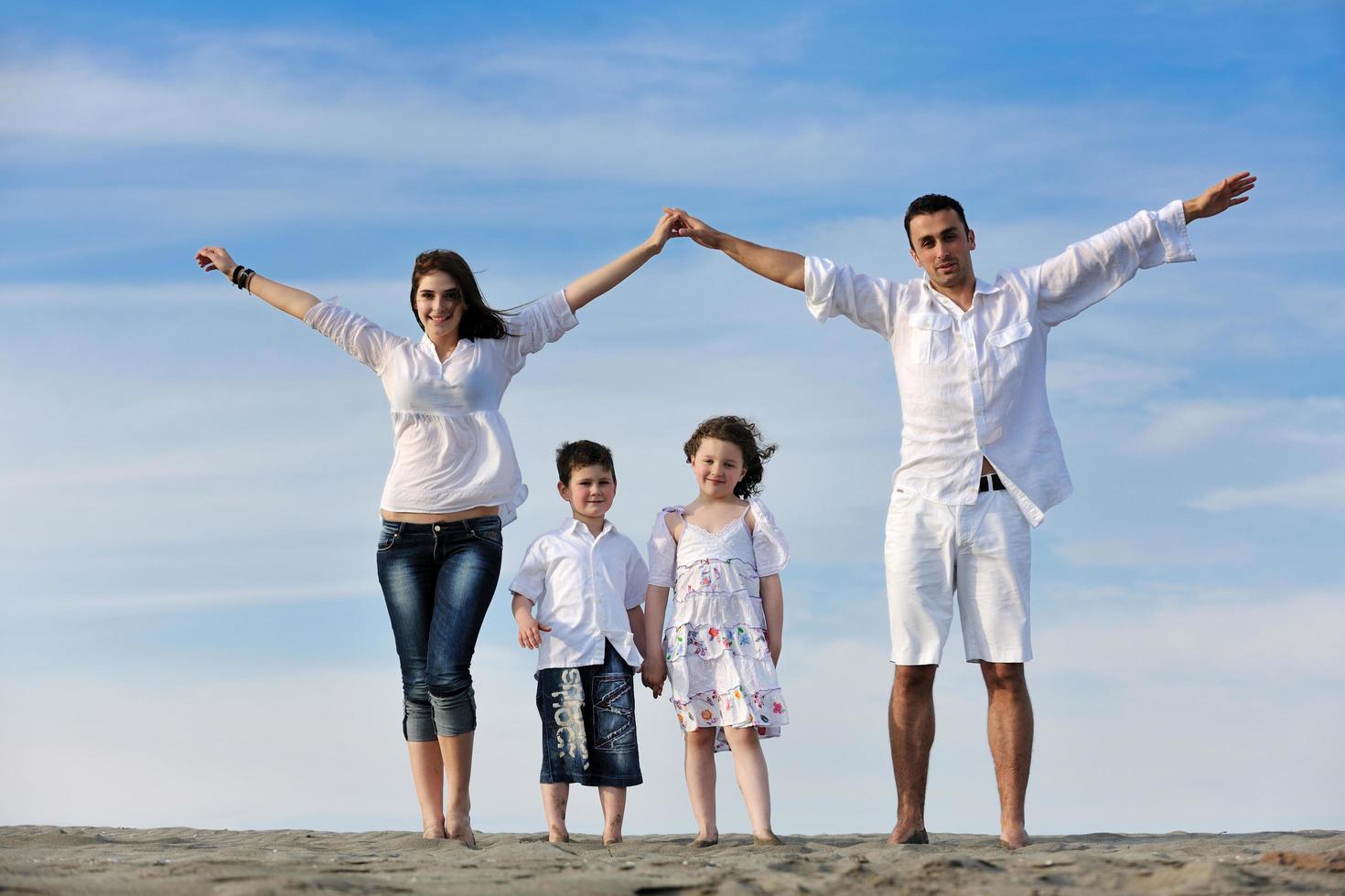 family on beach showing home sign photo