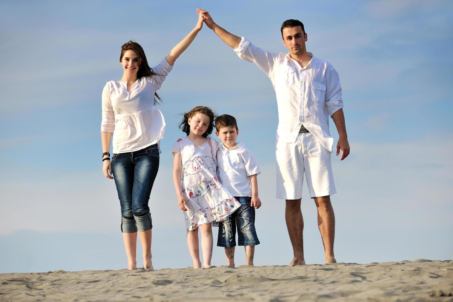 family on beach showing home sign photo