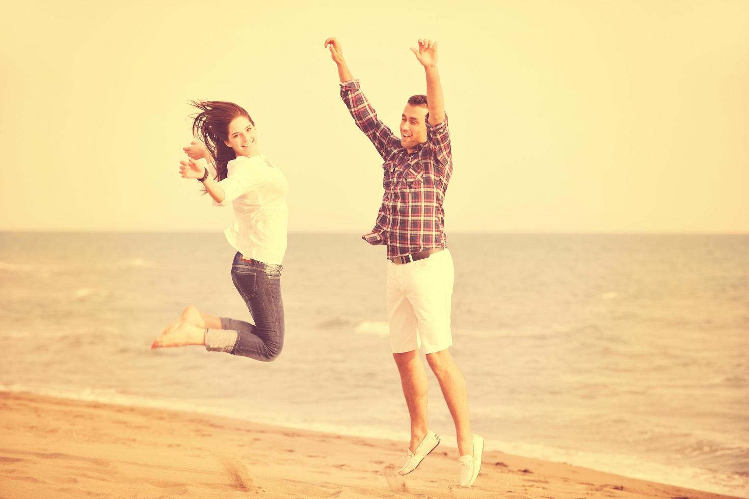 feliz pareja joven divertirse en la playa foto