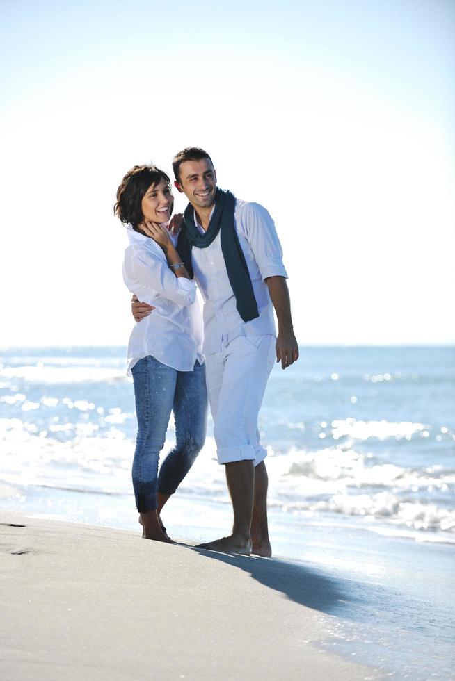 feliz pareja joven divertirse en la hermosa playa foto