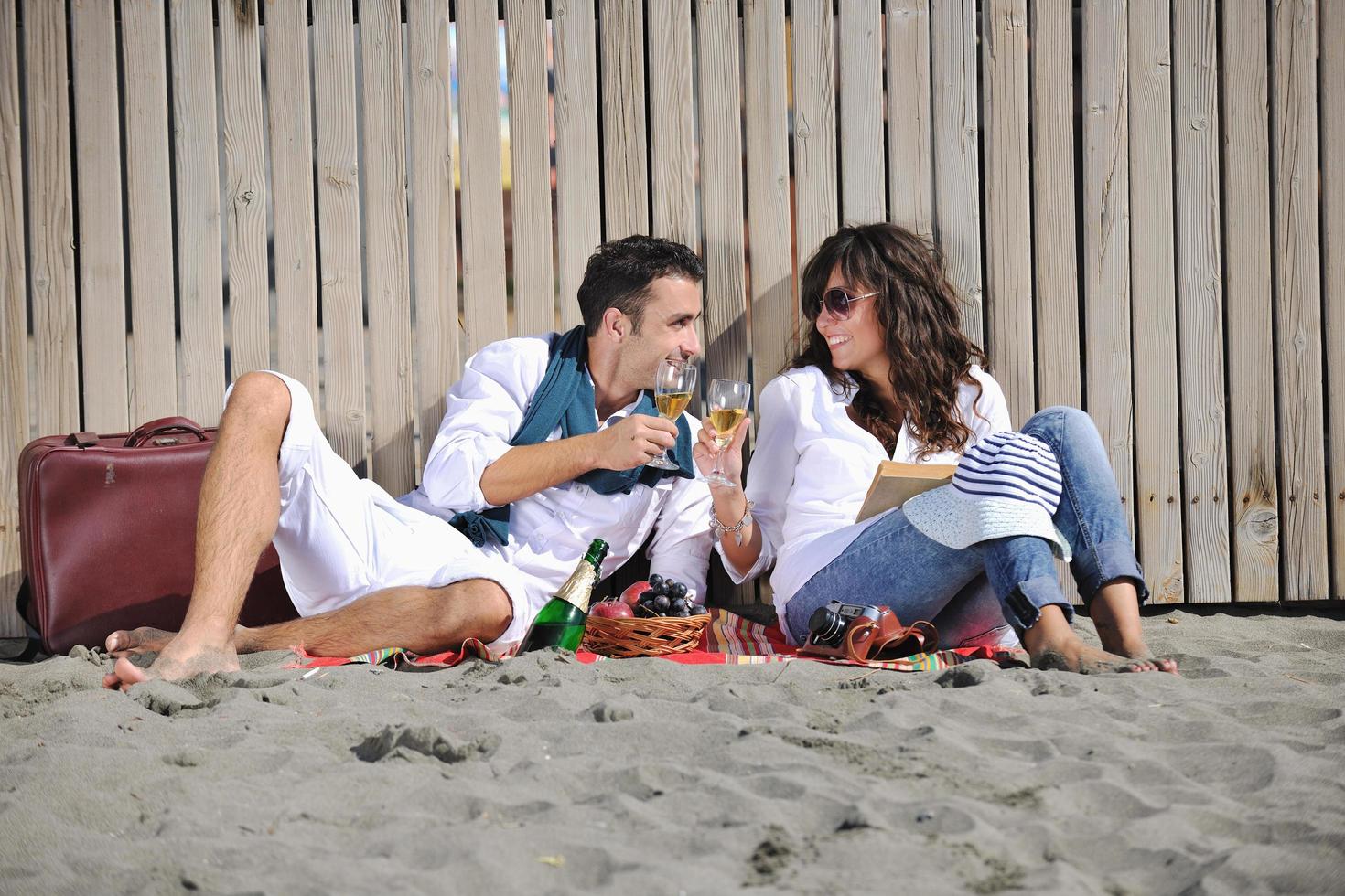 pareja joven disfrutando de un picnic en la playa foto