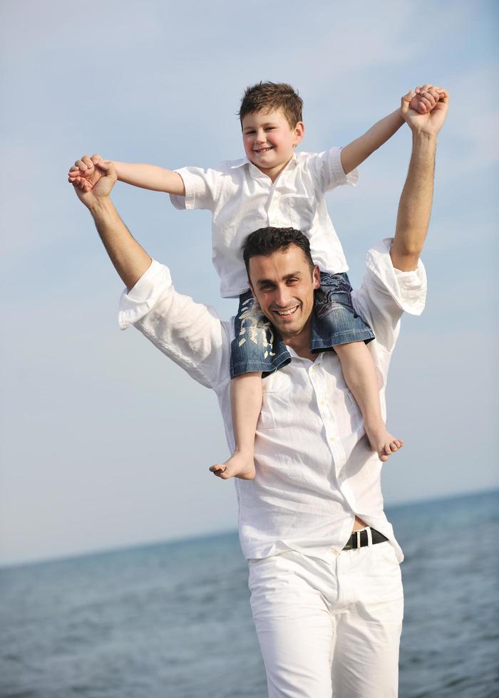 happy father and son have fun and enjoy time on beach photo