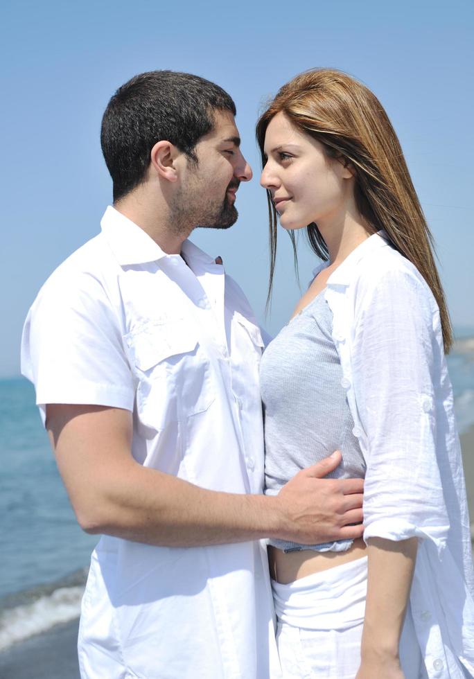 feliz pareja joven divertirse en la playa foto