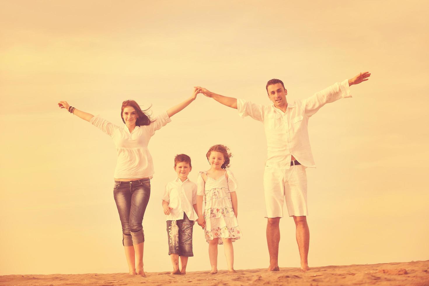 family on beach showing home sign photo