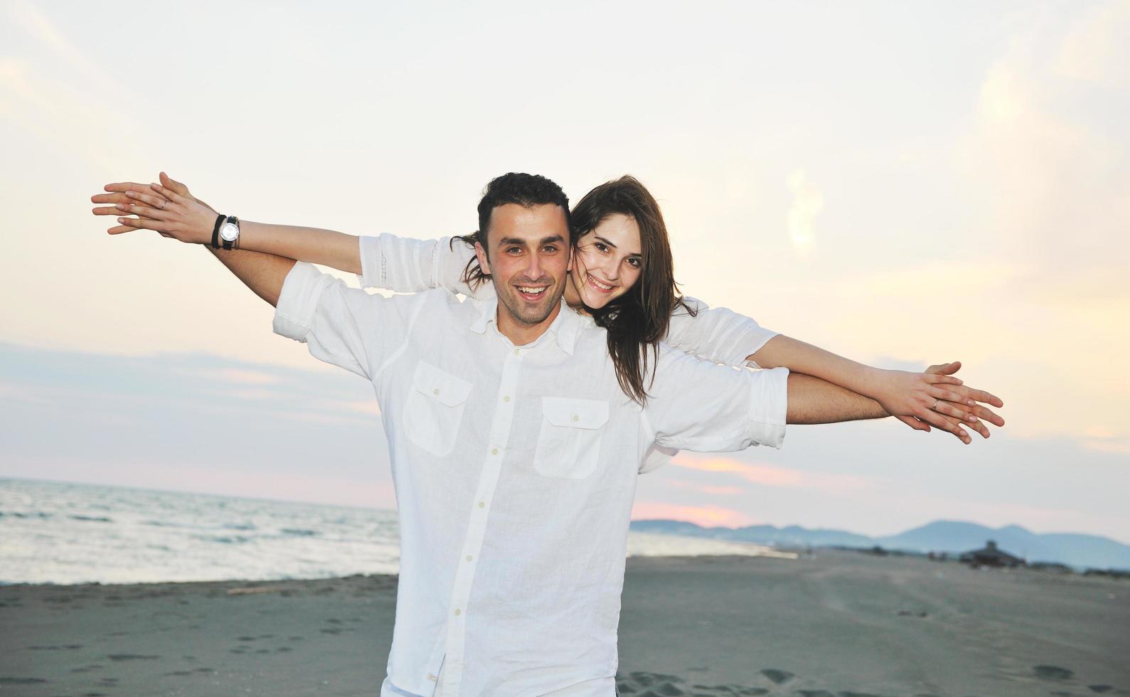 happy young couple have fun on beach photo