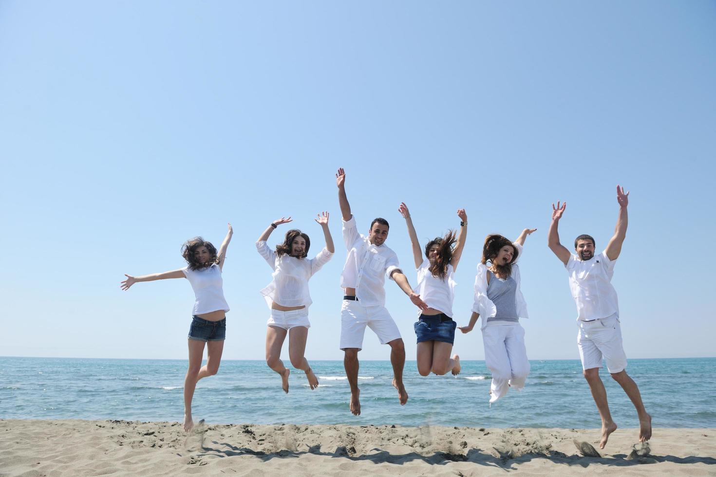 happy people group have fun and running on beach photo
