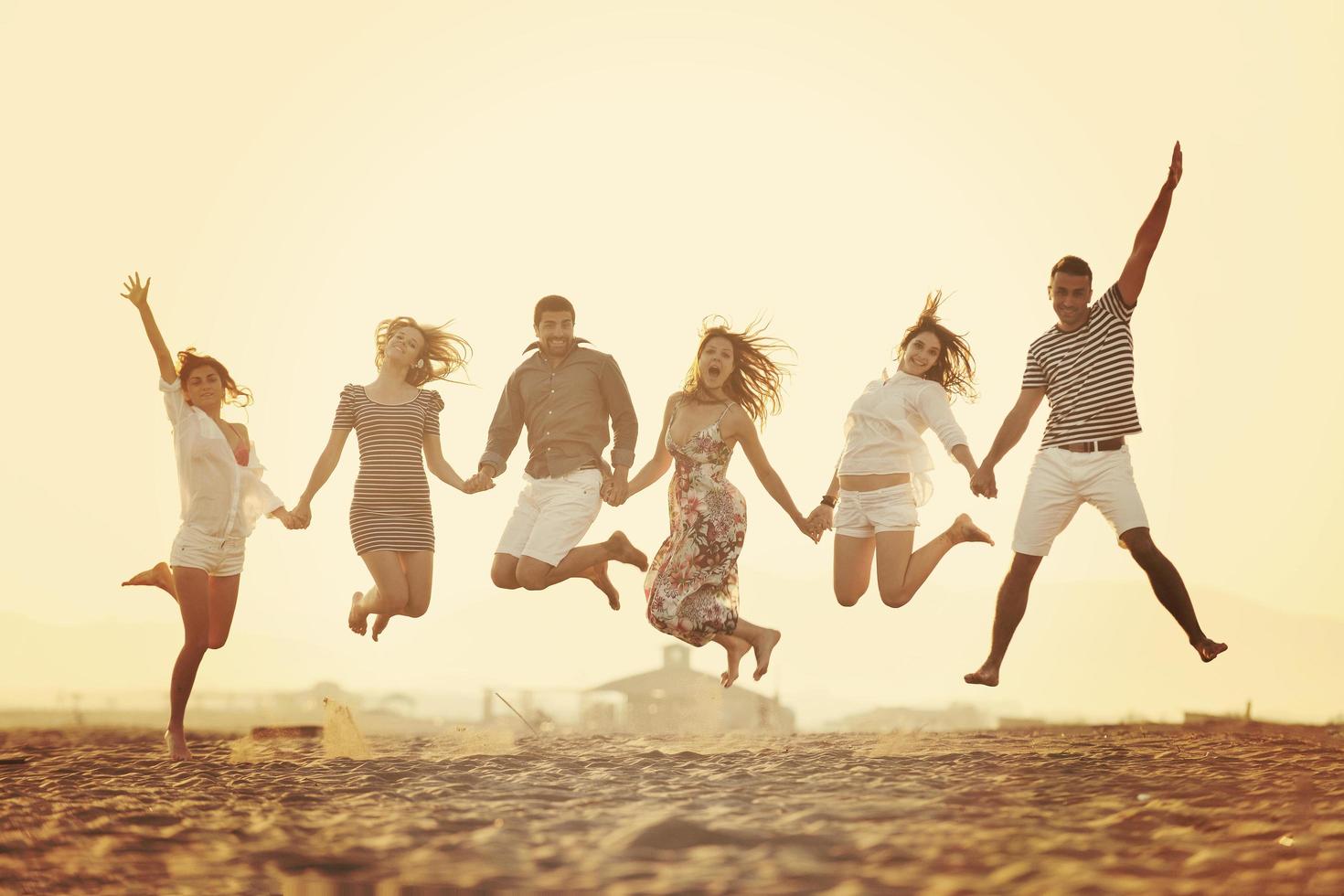 grupo de jóvenes felices divertirse en la playa foto