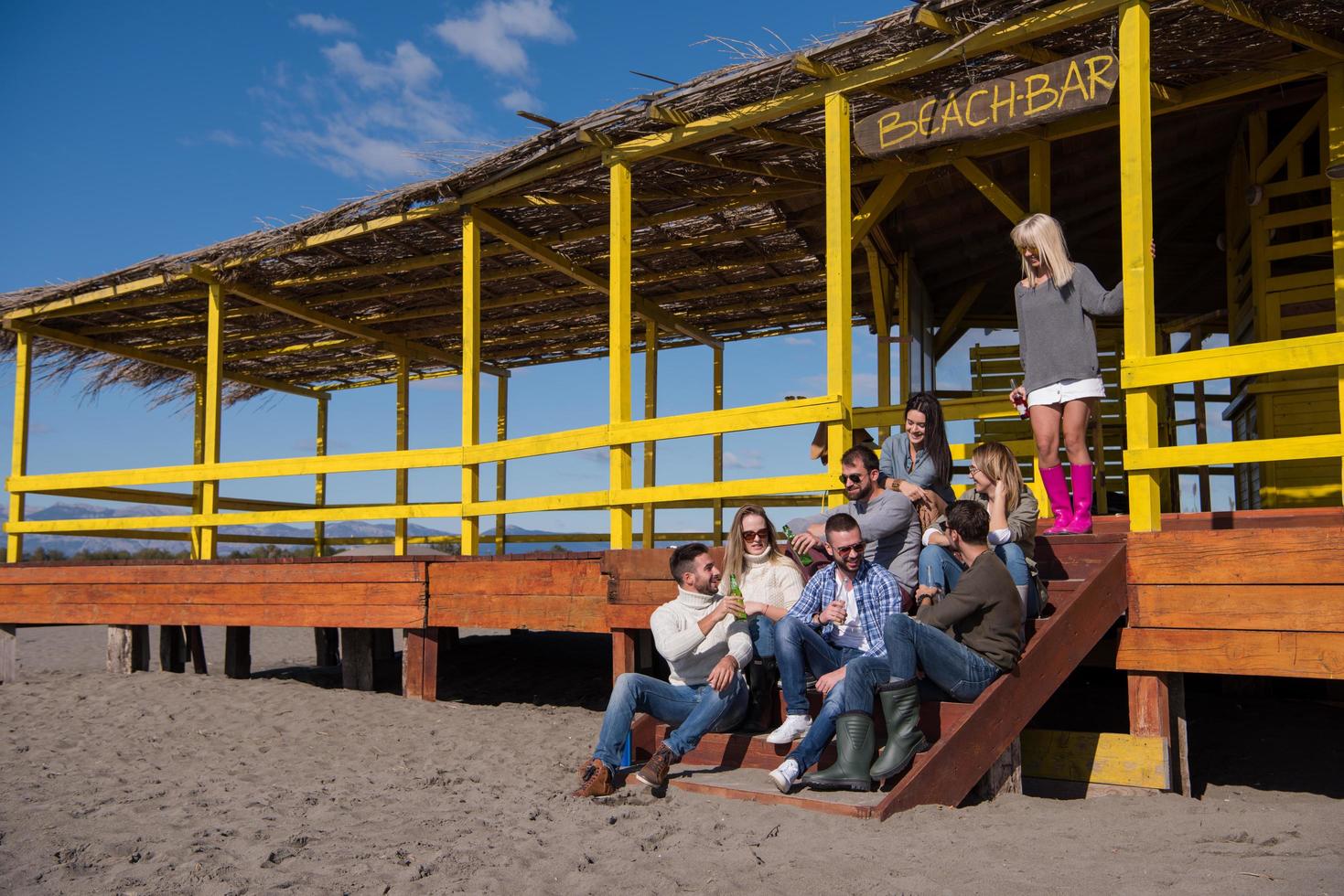 Group of friends having fun on autumn day at beach photo