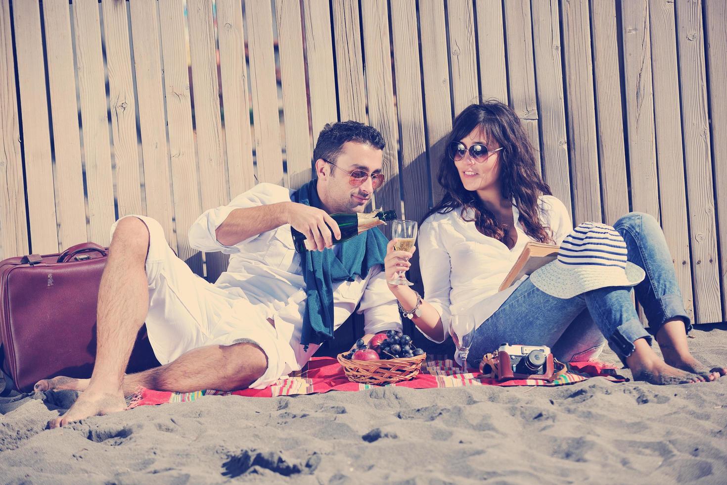 young couple enjoying  picnic on the beach photo