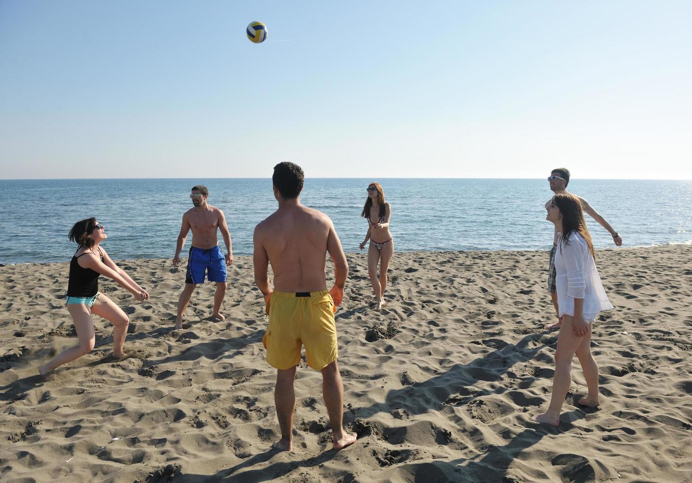 young people group have fun and play beach volleyball photo