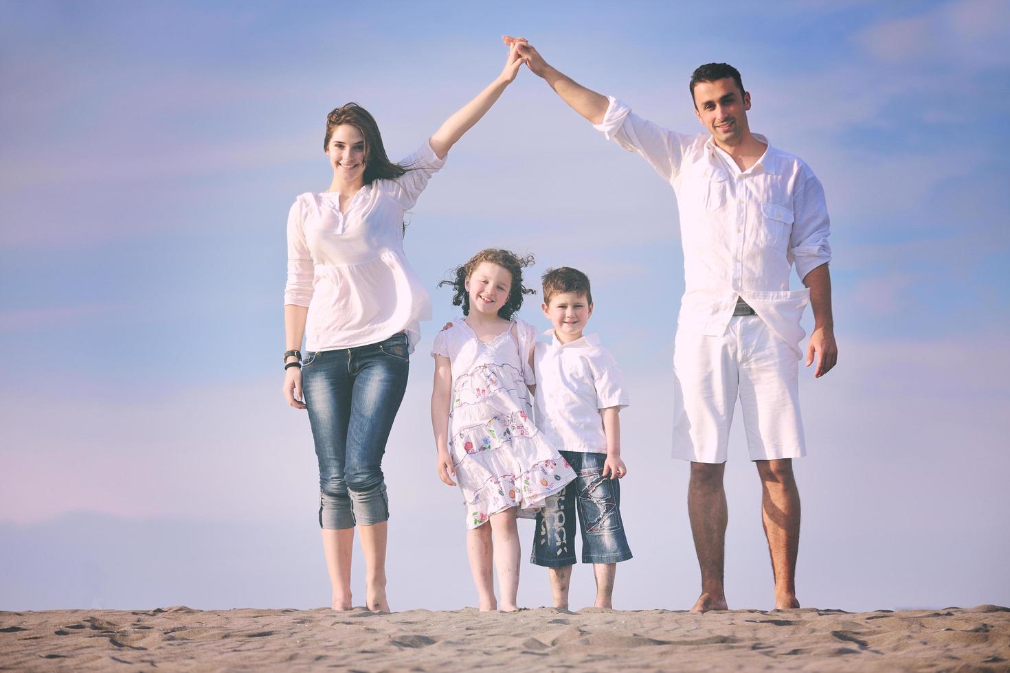 family on beach showing home sign photo