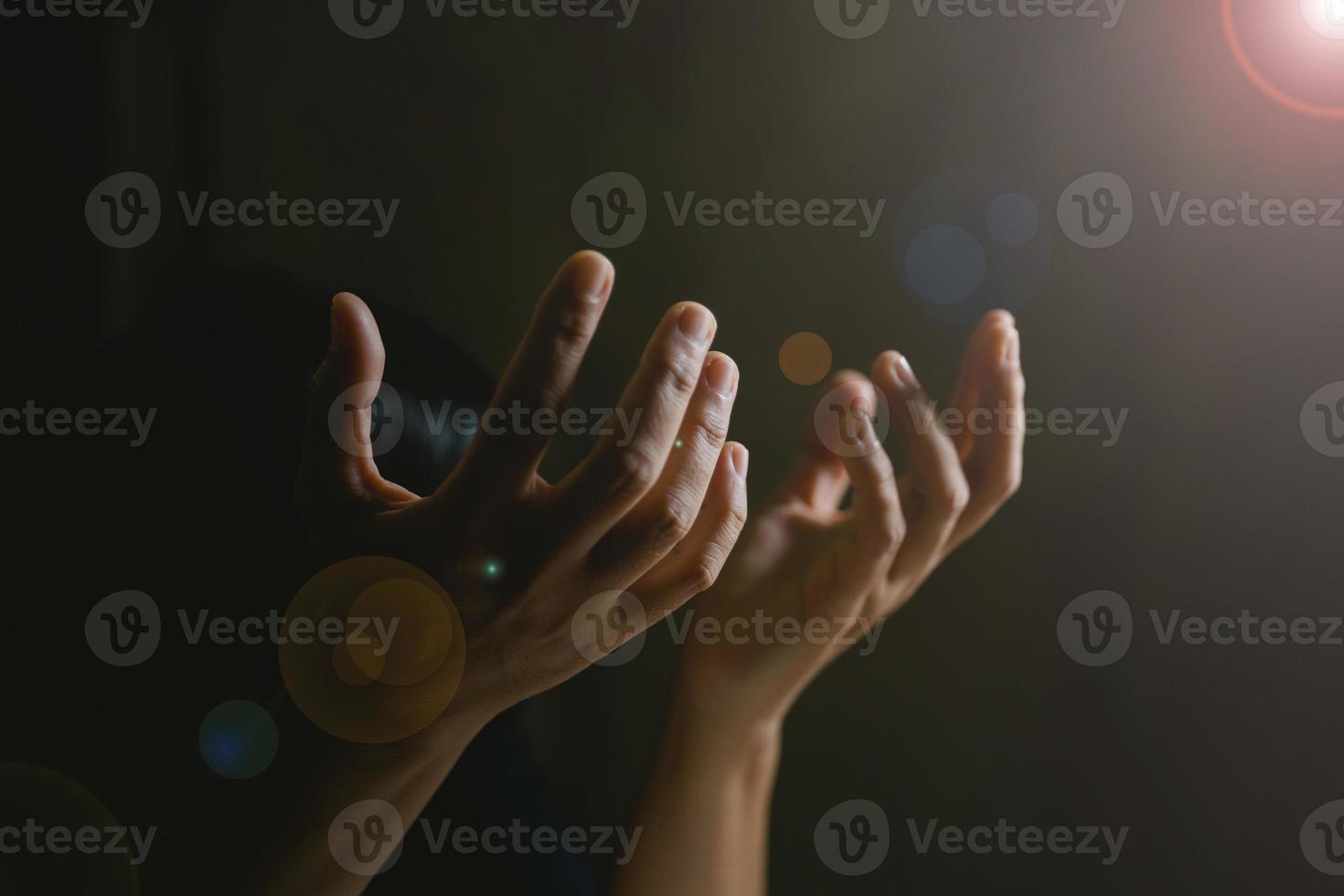 Prayer person hand in black background. Christian catholic woman are praying to god in dark at church. Girl believe and faith in jesus christ. Christ religion and christianity worship or pray concept. photo