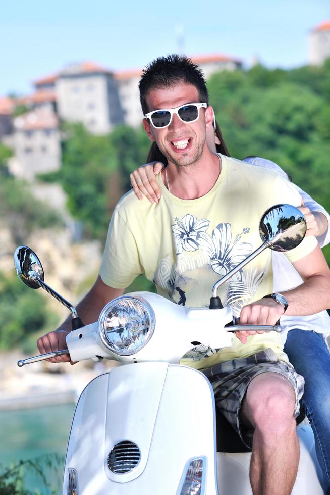 Portrait of happy young love couple on scooter enjoying summer time photo