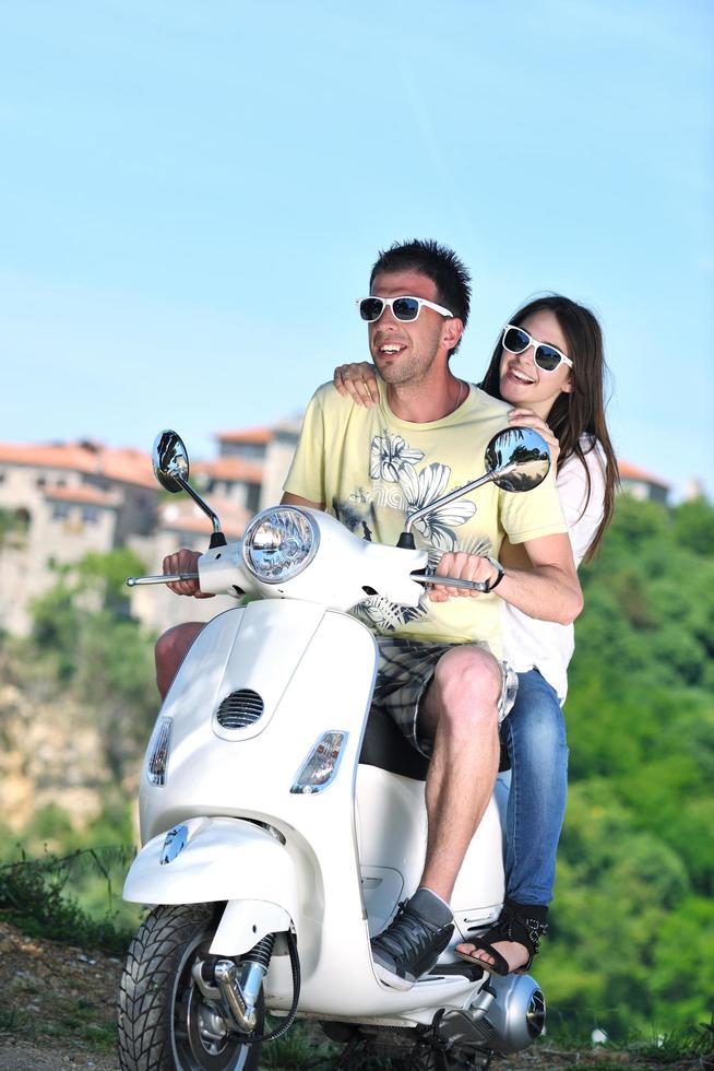 retrato de feliz pareja de amor joven en scooter disfrutando del verano foto