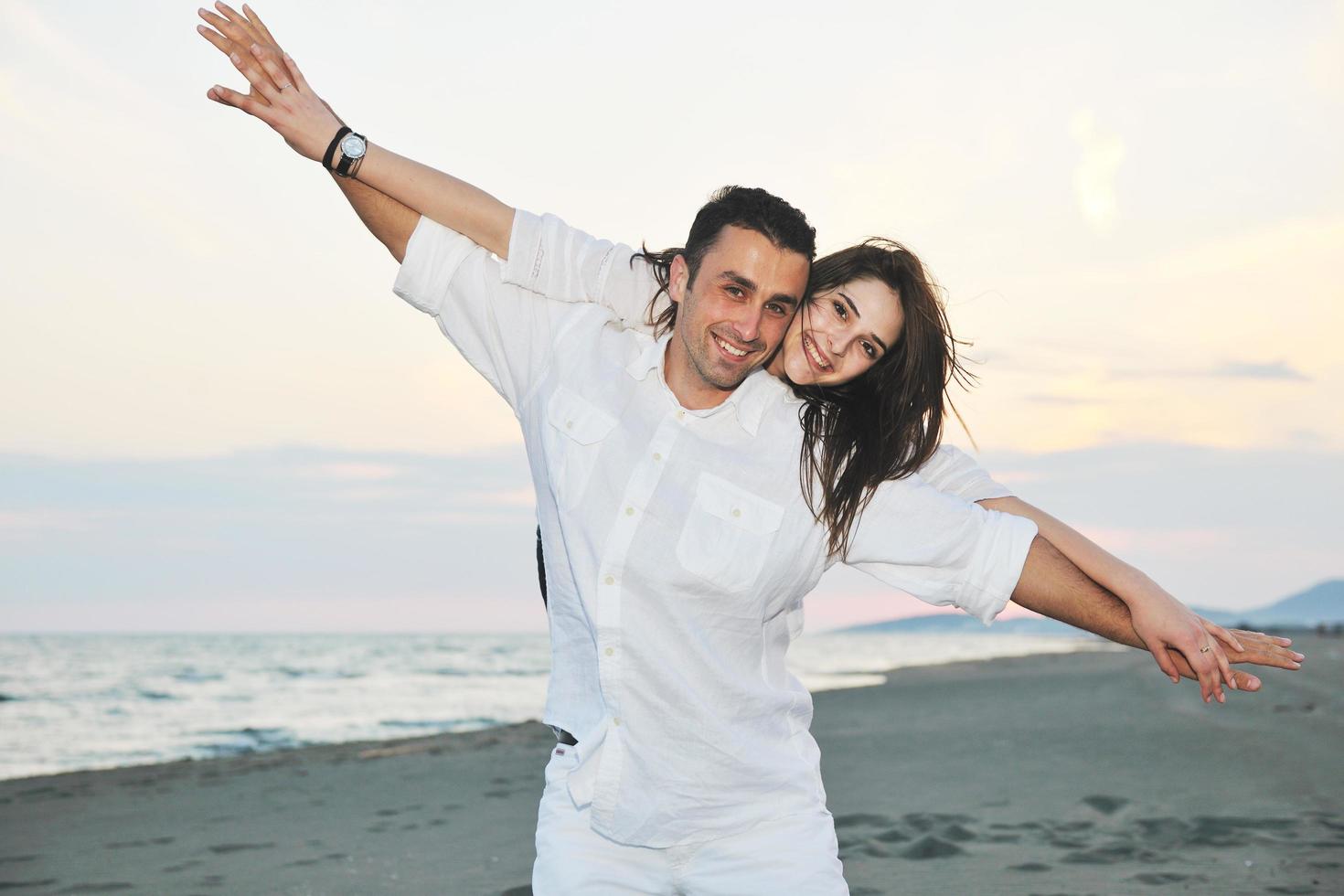 happy young couple have fun on beach photo