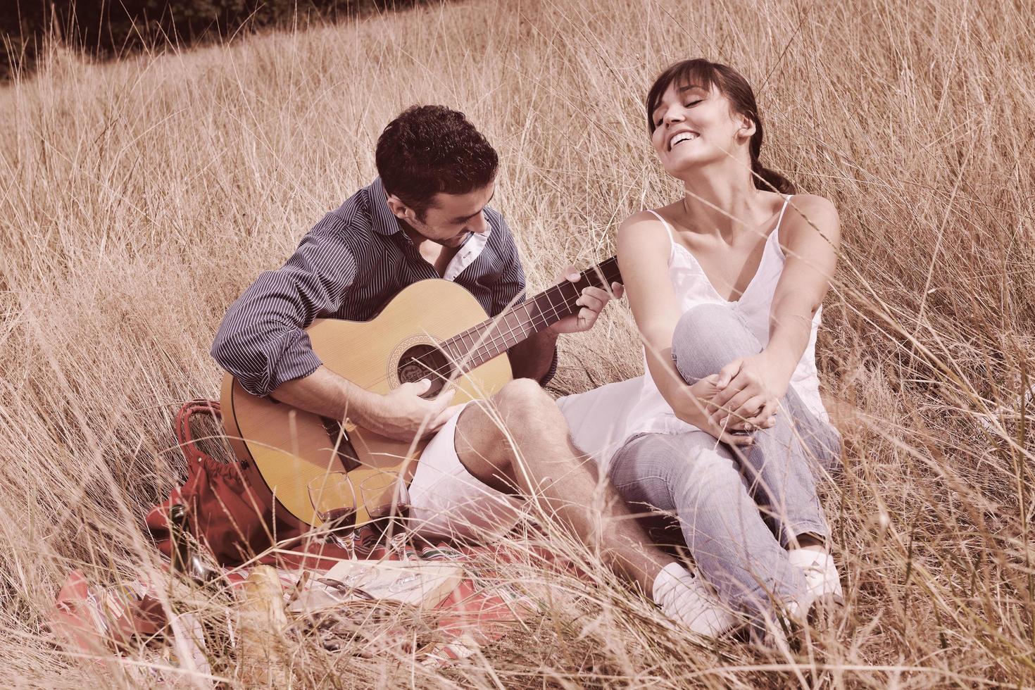 happy couple enjoying countryside picnic in long grass photo