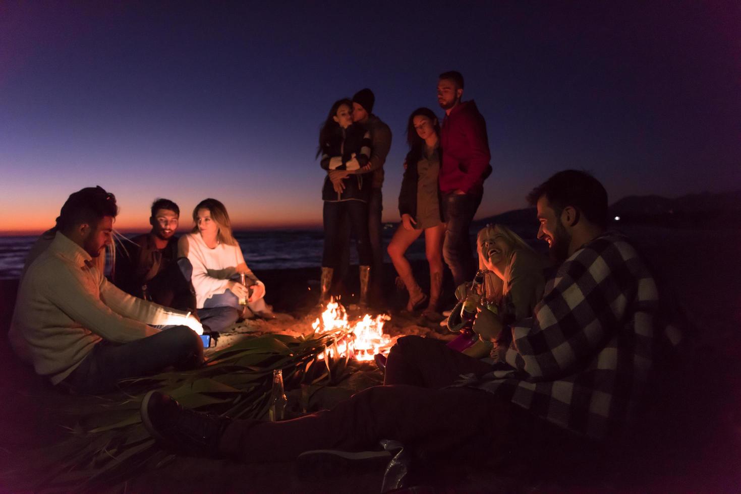 Friends having fun at beach on autumn day photo