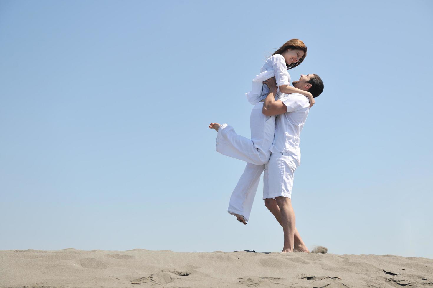 happy young couple have fun on beach photo