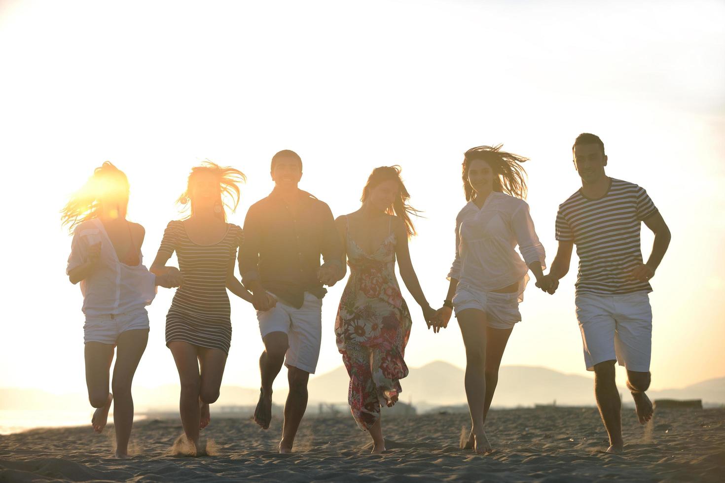 grupo de jóvenes felices divertirse en la playa foto