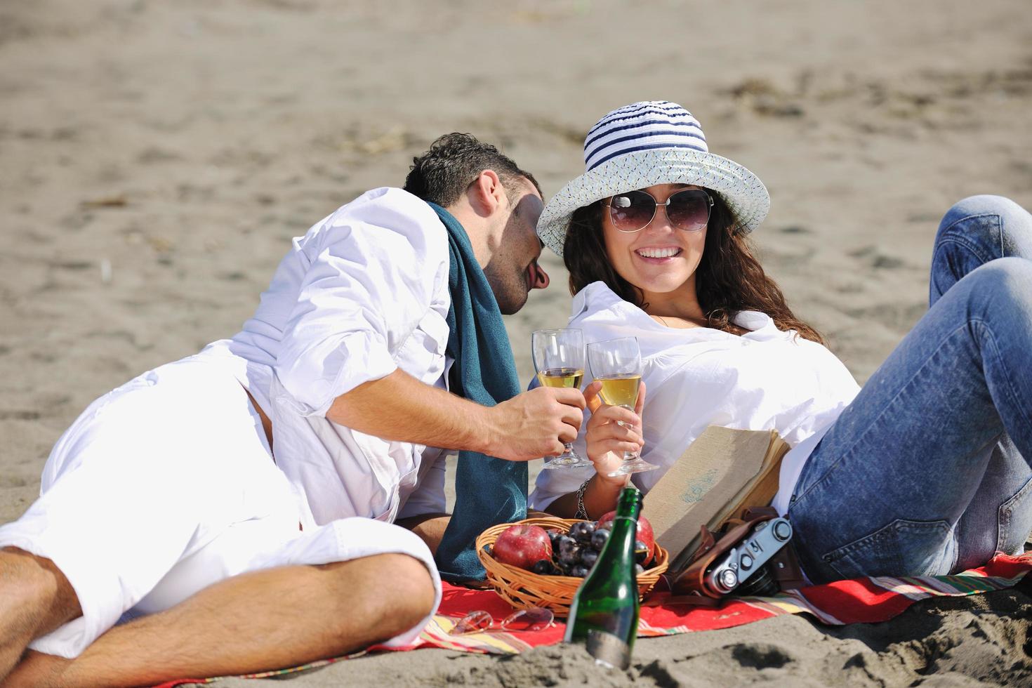 pareja joven disfrutando de un picnic en la playa foto