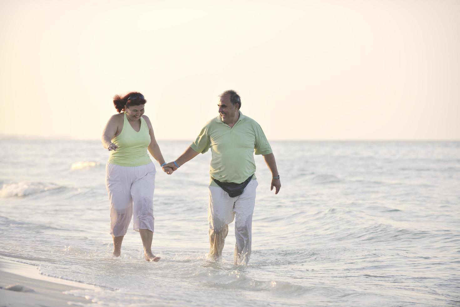 feliz pareja de ancianos en la playa foto