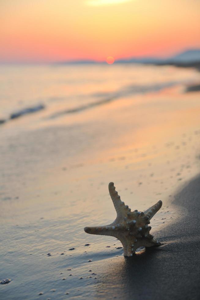 puesta de sol de playa de verano con estrella en la playa foto