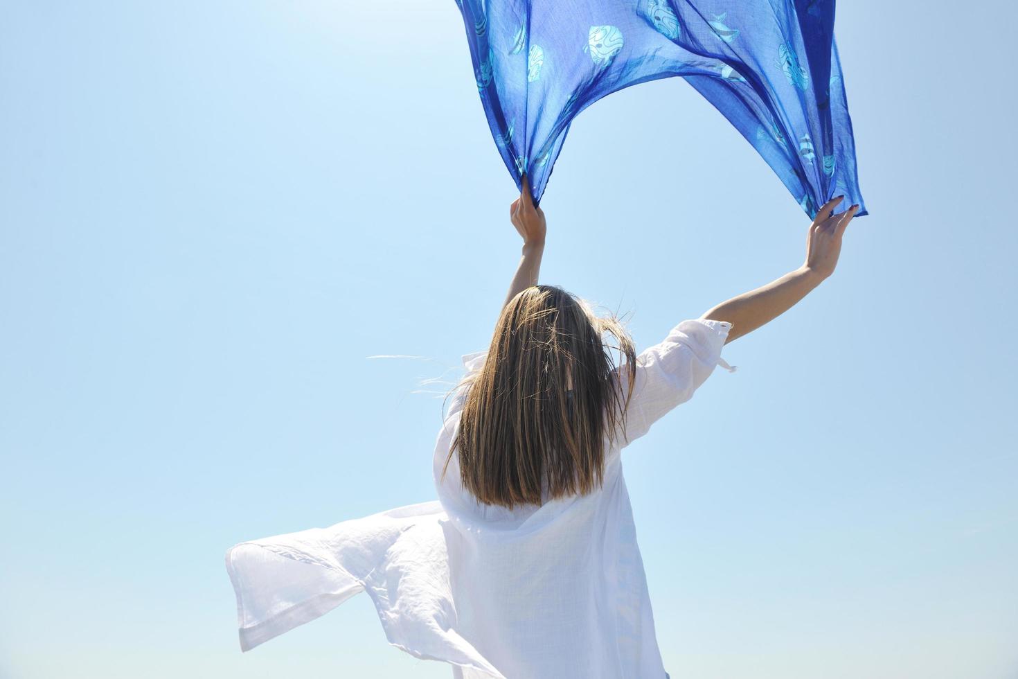 beautiful young woman on beach with scarf photo