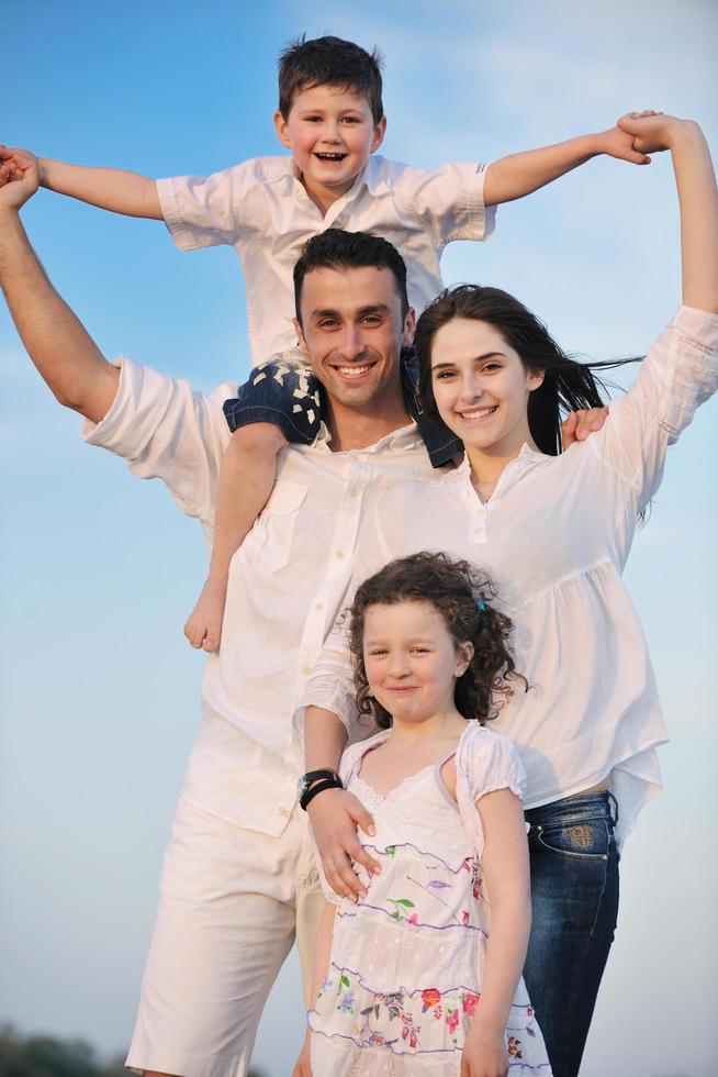 familia joven feliz divertirse en la playa foto